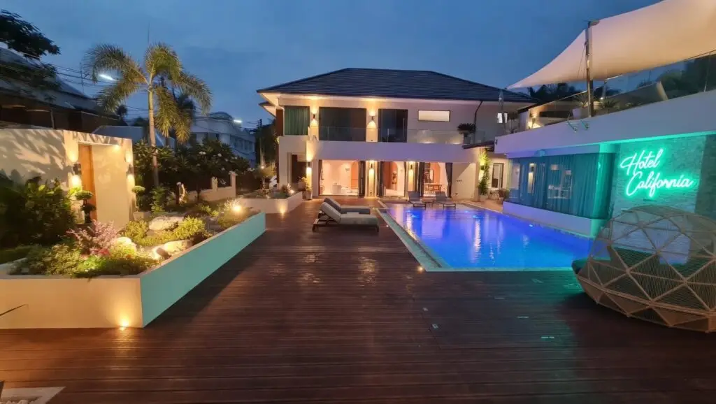 Luxury tropical landscape entrance with wooden deck, modern white planters and lush gardens completed in 2024 at Na Jomtien, Pattaya, Chonburi