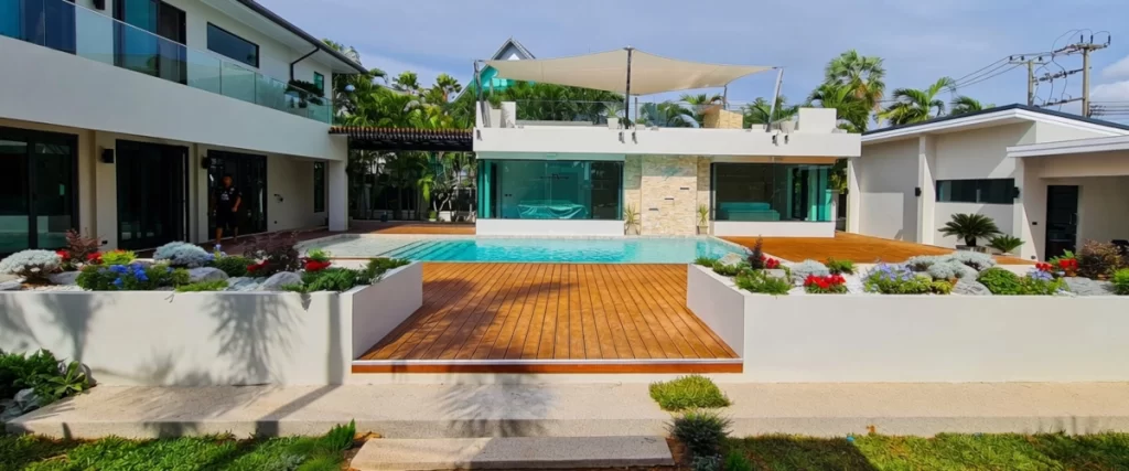 Luxury modern pool villa with wooden deck and white planters in Jomtien Pattaya by CSP Construction