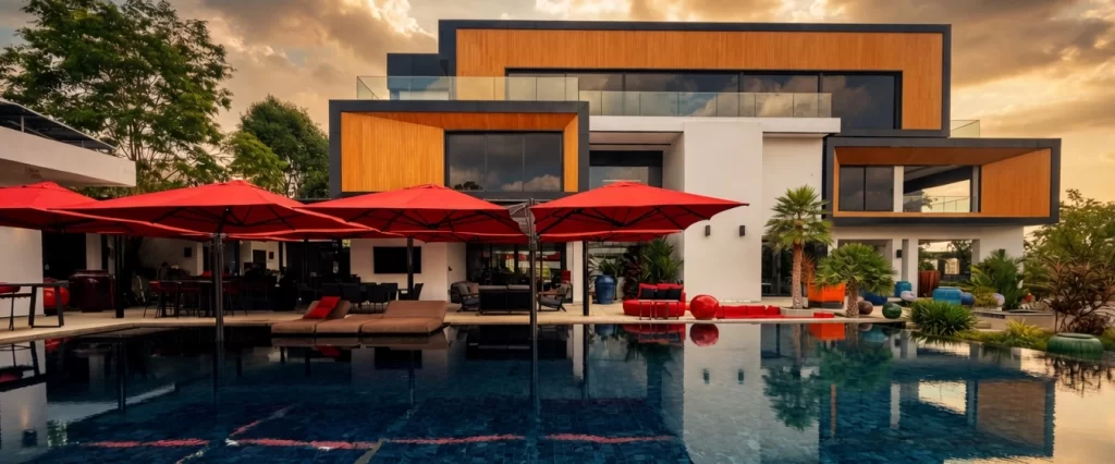 Contemporary luxury villa with red umbrellas and dramatic reflection pool at sunset – Pattaya